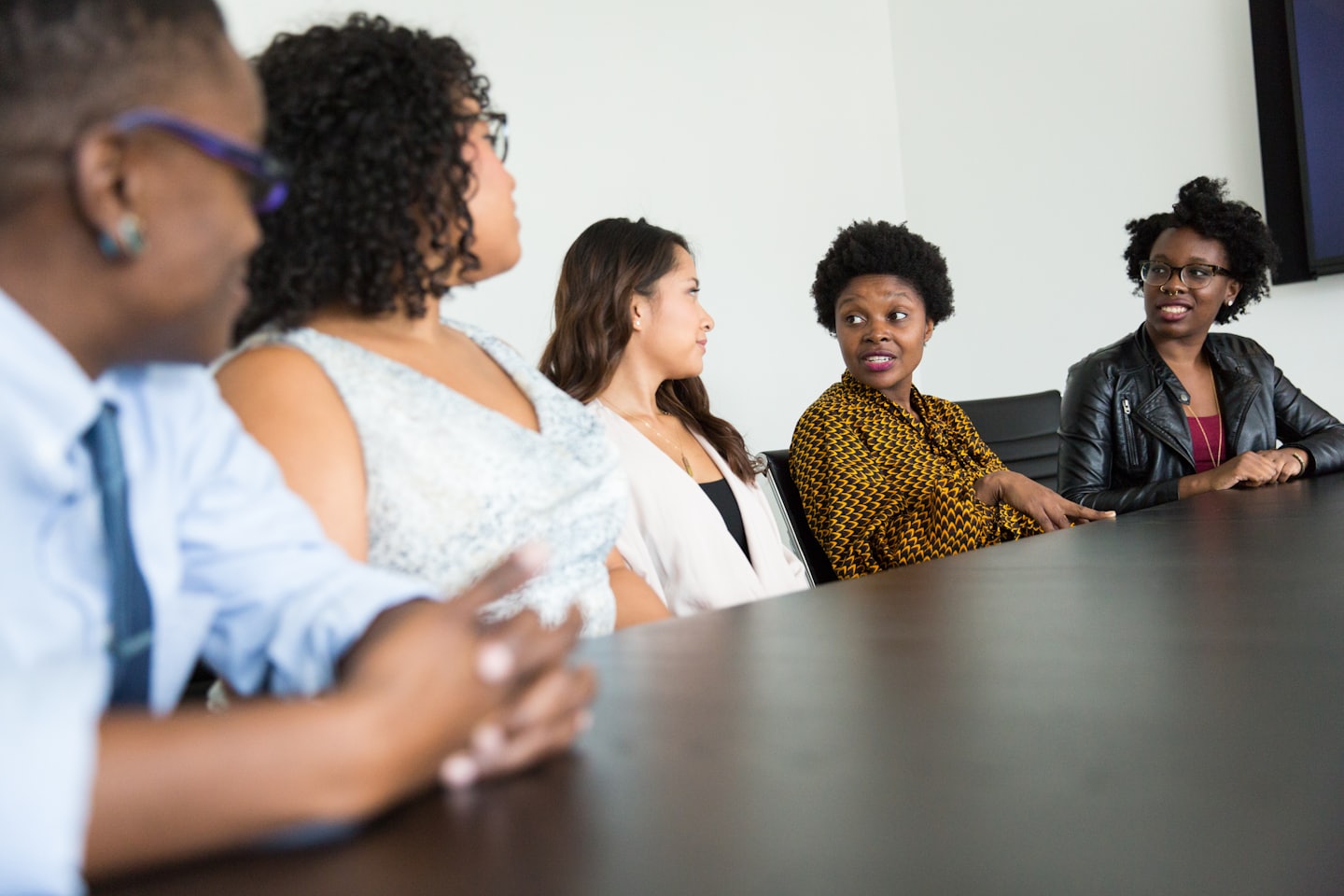 Des professionnels diversifiés collaborent autour d'une table de conférence lors d'une réunion.